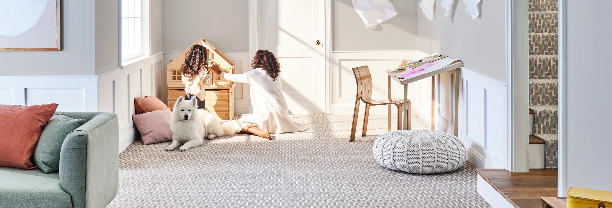 mother and daughter playing in living with dog beside them on patterned carpet by Michaels Carpets Huntington Beach in Huntington Beach, CA